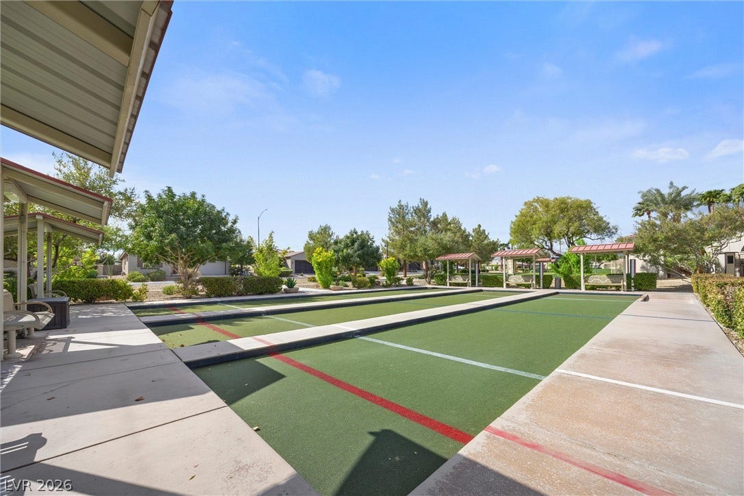 5824 Pleasant Palms Street, North Las Vegas, NV 89081 Well-maintained community shuffleboard courts sit adjacent to concrete walkways under a clear blue sky.