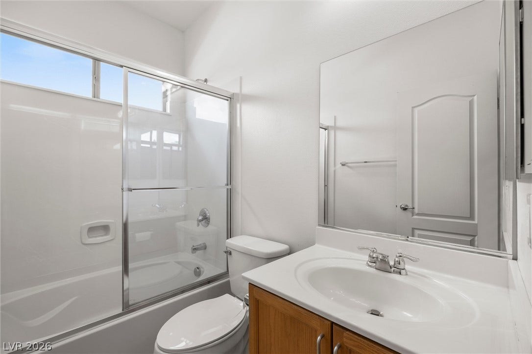 5824 Pleasant Palms Street, North Las Vegas, NV 89081 downstairs full bathroom: A glass-enclosed shower and tub combination sits adjacent to a classic single-sink vanity.