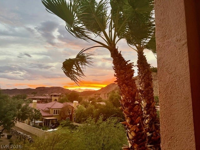 30 Via Vasari, #102, Henderson, NV 89011 Distant hills frame a colorful sunset over the surrounding neighborhood landscape.