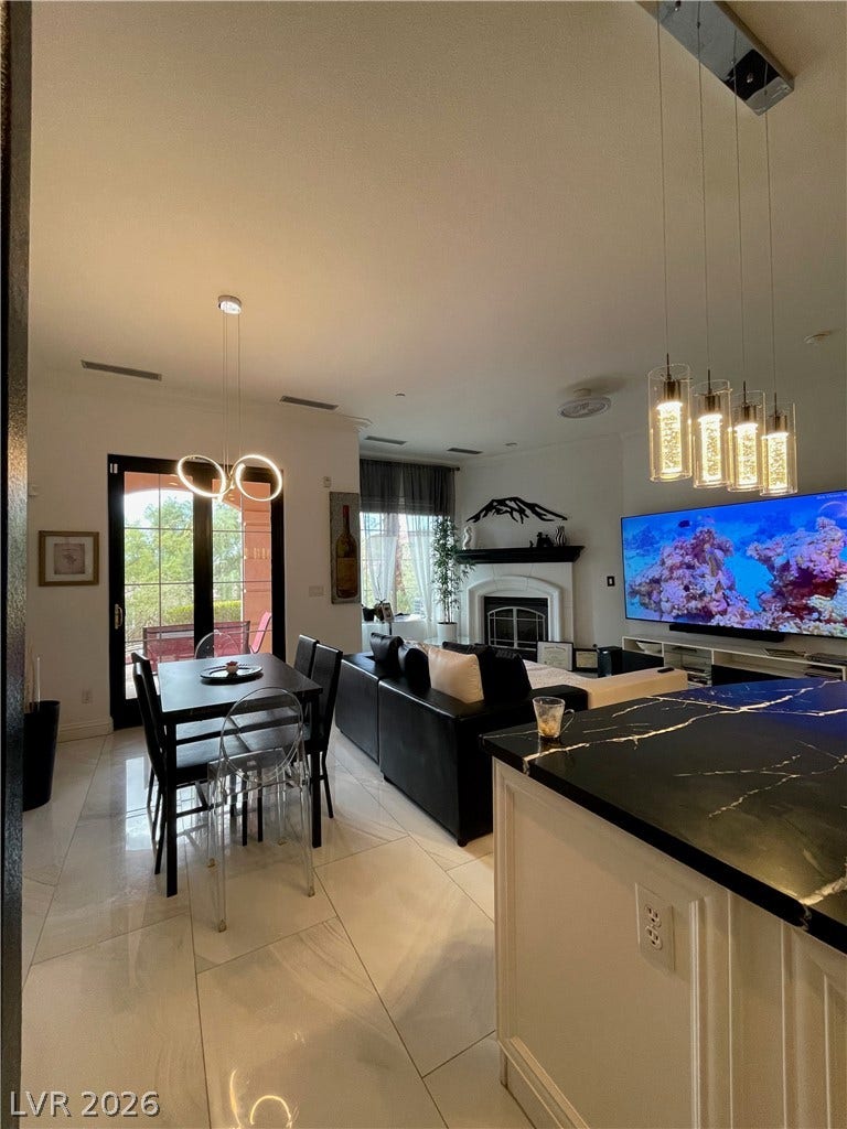 30 Via Vasari, #102, Henderson, NV 89011 Gleaming tile floors and a grand fireplace anchor this sophisticated open living space.