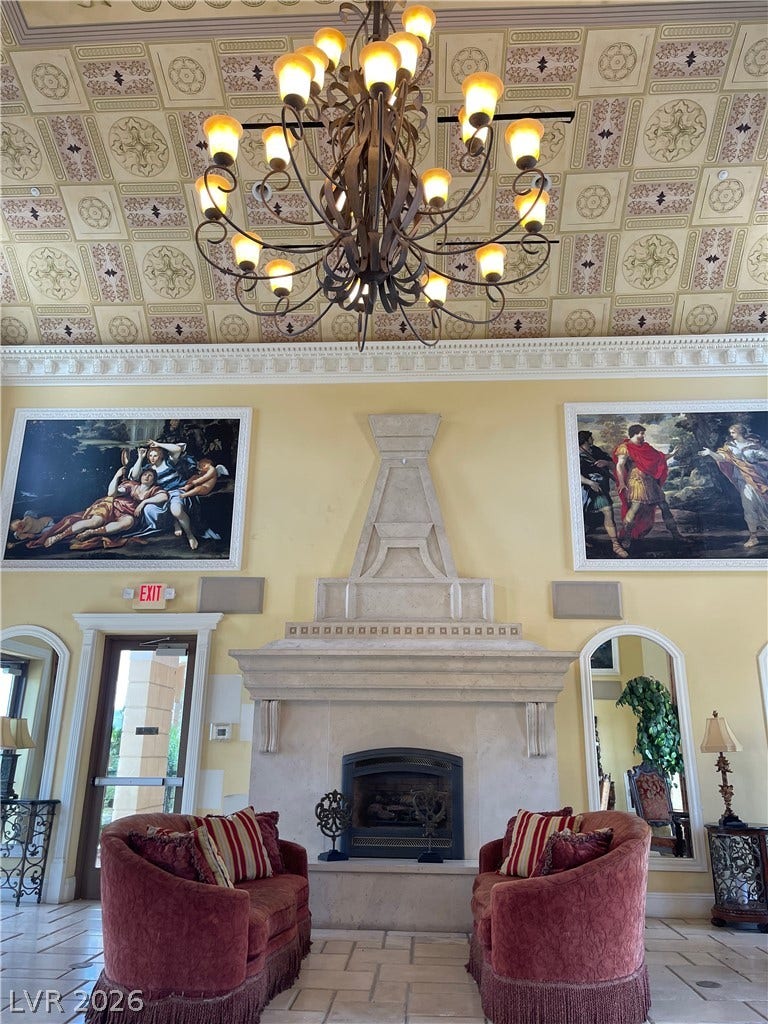 30 Via Vasari, #102, Henderson, NV 89011 Ornate coffered ceilings and a grand stone fireplace define this elegant formal living room.
