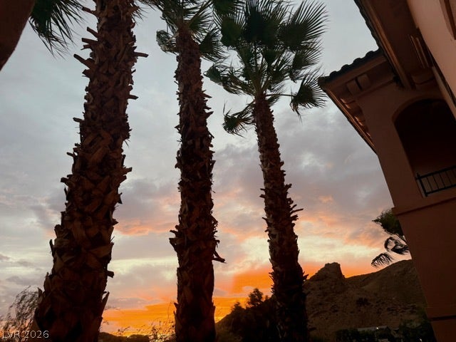 30 Via Vasari, #102, Henderson, NV 89011 Soaring palm trees frame dramatic desert mountain views against a vibrant sunset sky.