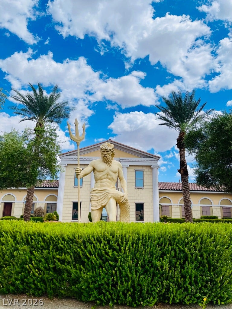 30 Via Vasari, #102, Henderson, NV 89011 Lush manicured hedges and towering palms frame a grand classical estate facade.