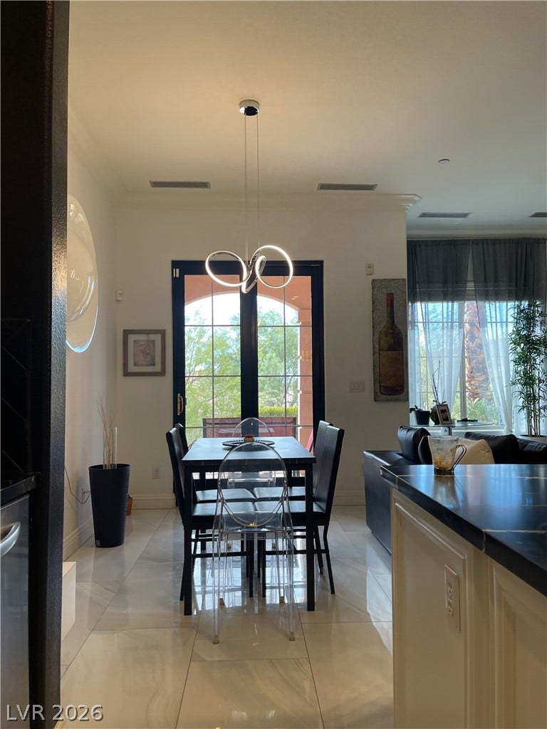 30 Via Vasari, #102, Henderson, NV 89011 Polished tile flooring and double glass doors define this open dining space.
