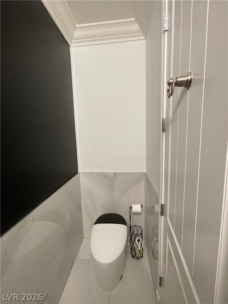 30 Via Vasari, #102, Henderson, NV 89011 Polished wall tile and classic crown molding elevate this sleek powder room design.