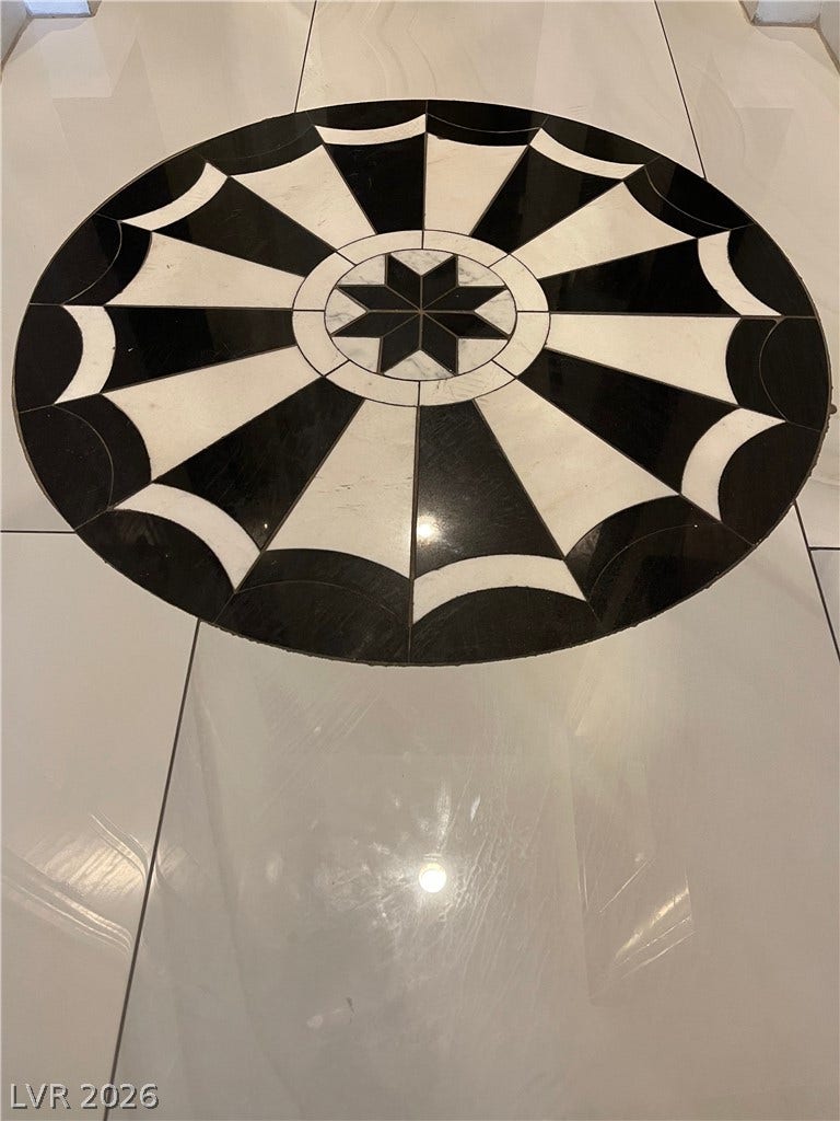 30 Via Vasari, #102, Henderson, NV 89011 An intricate geometric stone medallion creates a striking focal point on the polished entryway floor.