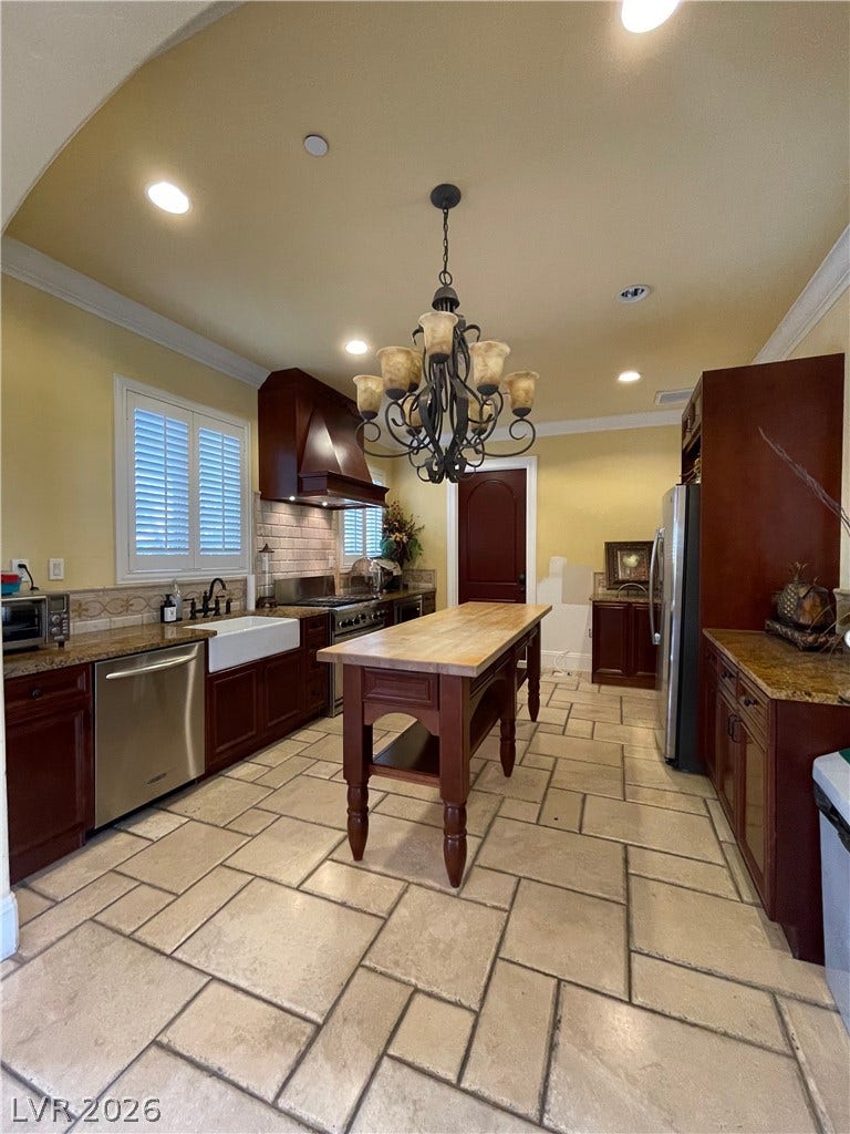 30 Via Vasari, #102, Henderson, NV 89011 Rich wood cabinetry and stone countertops accent this kitchen featuring a central island.