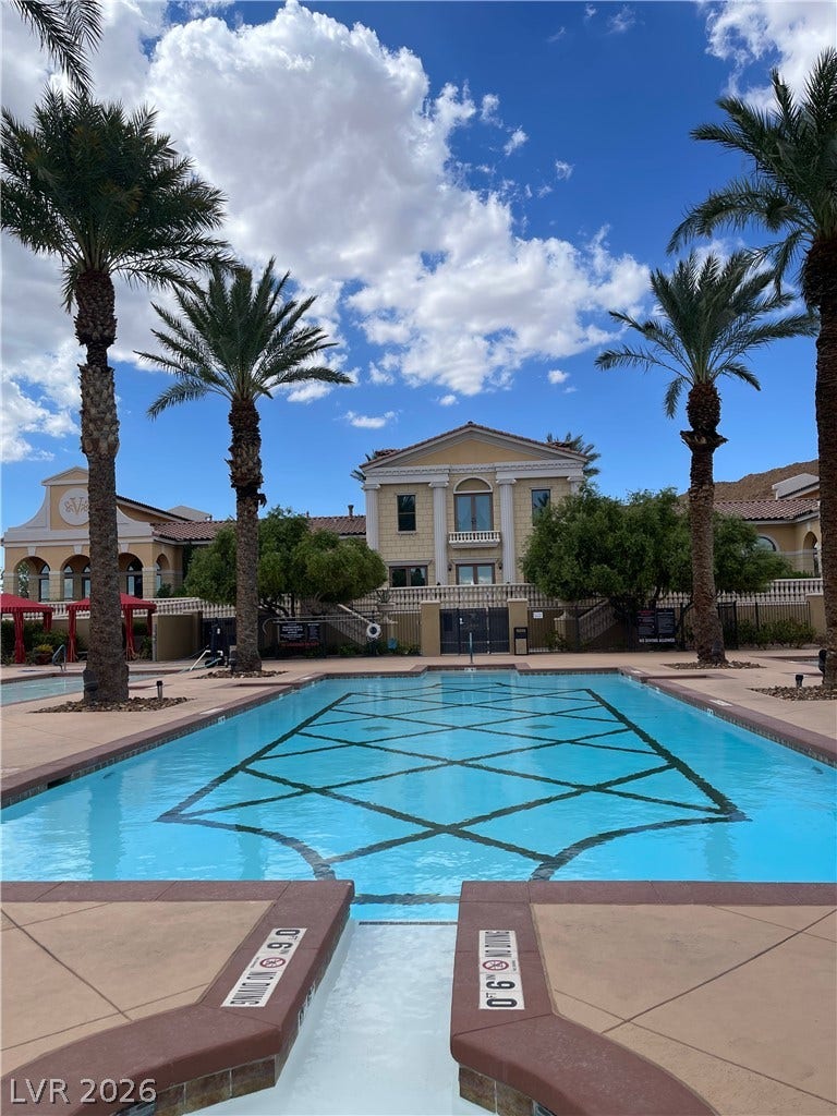 30 Via Vasari, #102, Henderson, NV 89011 Palm trees frame a sparkling community pool set against classic architectural details.