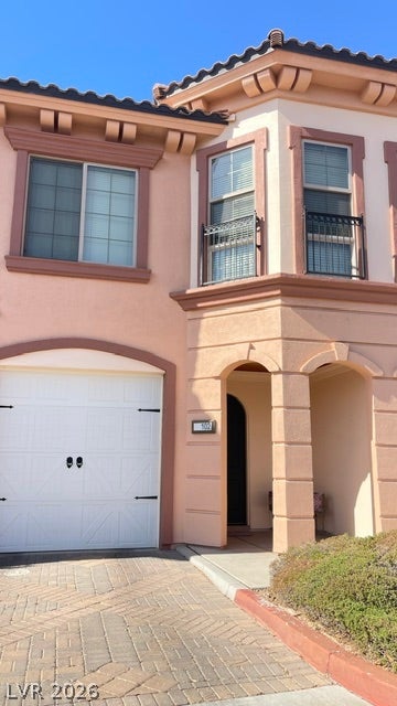 30 Via Vasari, #102, Henderson, NV 89011 Spanish tile roofing and an arched entryway define the Mediterranean exterior of this townhouse.