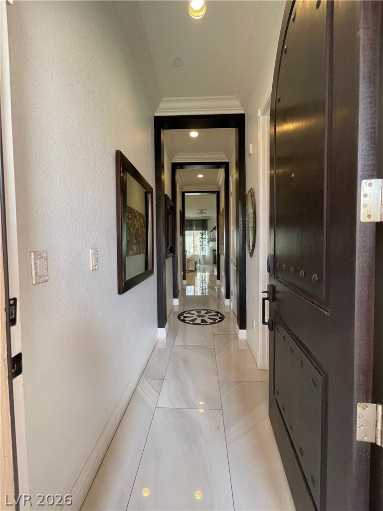 30 Via Vasari, #102, Henderson, NV 89011 Polished tile flooring guides guests through a series of elegant, dark-trimmed arched passageways.