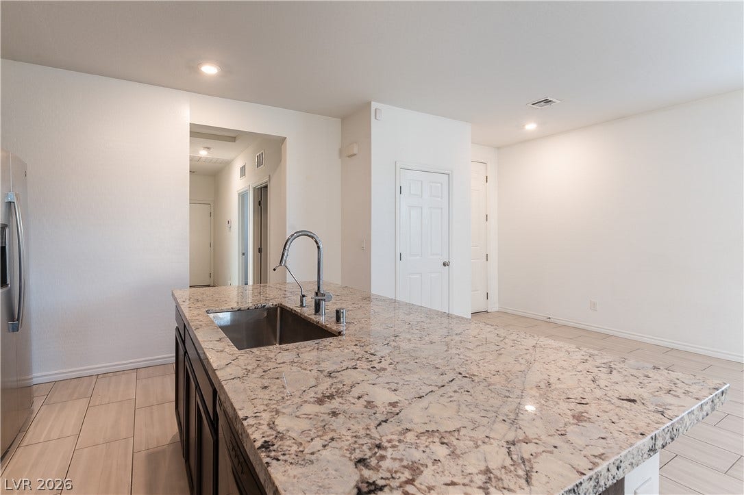 5740 Saltrock Grove Street, North Las Vegas, NV 89081 Granite countertops and tile flooring create an elegant backdrop in this functional kitchen.