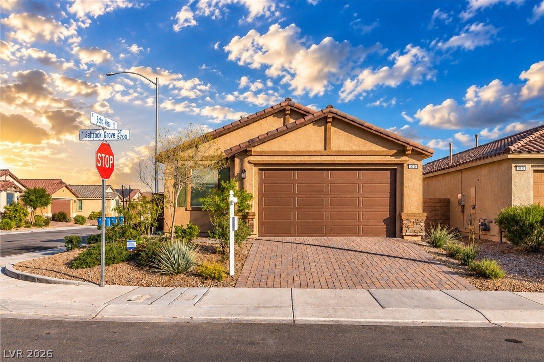 5740 Saltrock Grove Street, North Las Vegas, NV 89081 A classic stucco exterior features a tiled roof and a paved driveway leading to the garage.