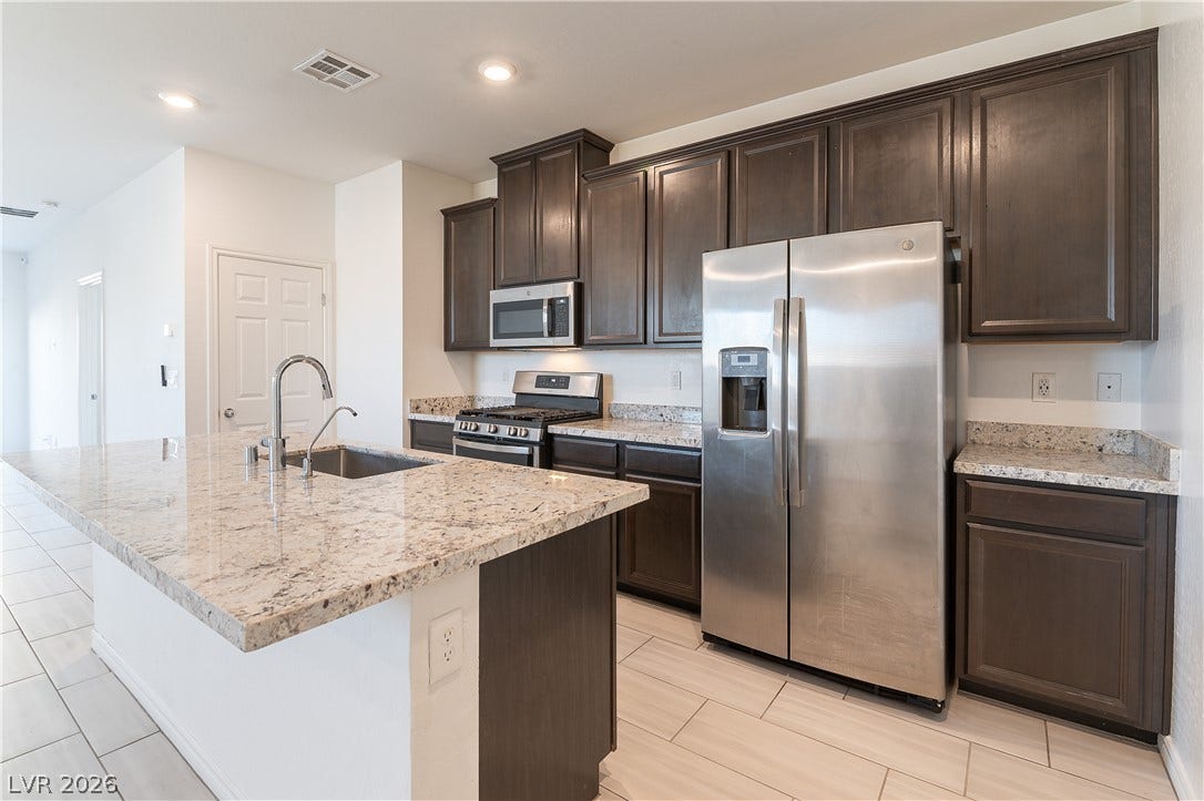 5740 Saltrock Grove Street, North Las Vegas, NV 89081 Rich dark cabinetry pairs beautifully with expansive granite countertops and modern stainless steel appliances.