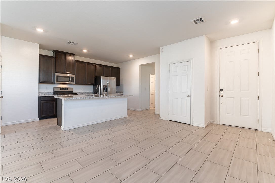 5740 Saltrock Grove Street, North Las Vegas, NV 89081 Clean tile flooring flows seamlessly from the entry into an open-concept kitchen.