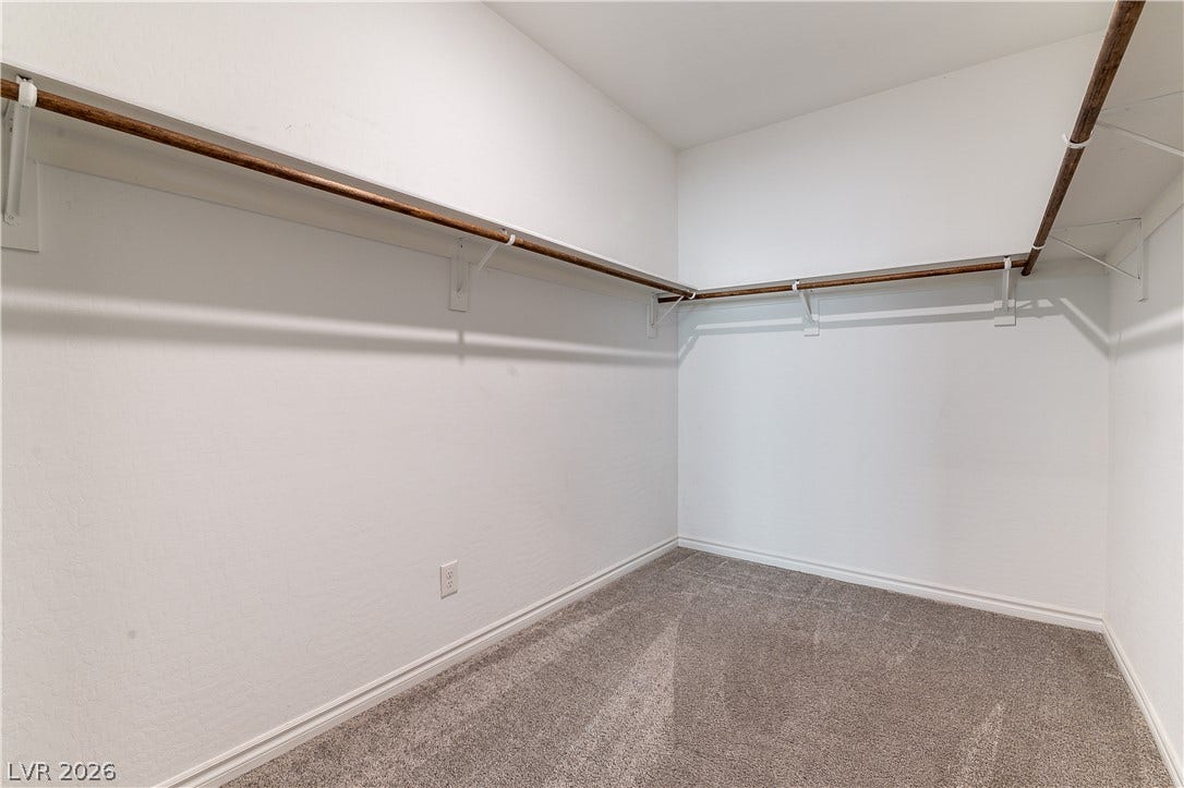 5740 Saltrock Grove Street, North Las Vegas, NV 89081 Ample hanging rods and soft carpeting define this functional walk-in closet space.