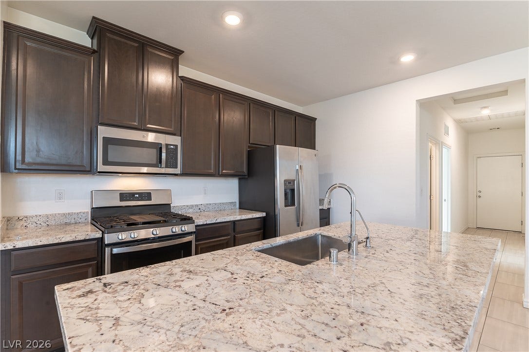 5740 Saltrock Grove Street, North Las Vegas, NV 89081 Rich dark wood cabinetry stands out against light granite countertops in this modern kitchen.