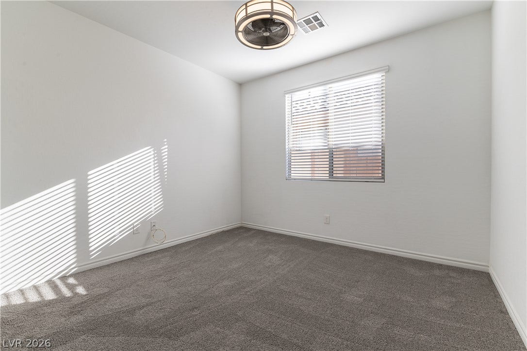 5740 Saltrock Grove Street, North Las Vegas, NV 89081 Plush carpeting anchors this versatile room with a well-placed window streaming in natural light.