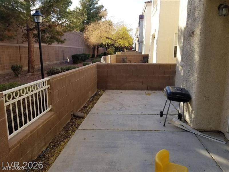 3123 Inlet Bay Avenue, North Las Vegas, NV 89031 An enclosed concrete patio area features block wall fencing alongside the home exterior.