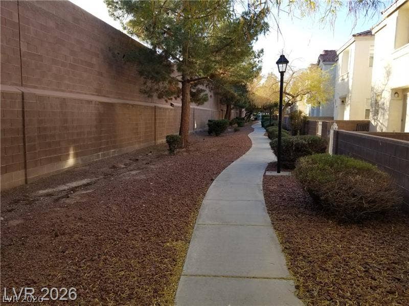 3123 Inlet Bay Avenue, North Las Vegas, NV 89031 A paved community sidewalk meanders past residential structures and landscaped gravel borders.
