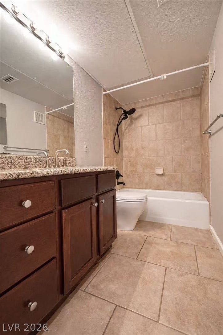 2838 Loveland Drive, #1608, Las Vegas, NV 89109 A classic tiled shower surround complements the dark wood vanity in this cozy bathroom.