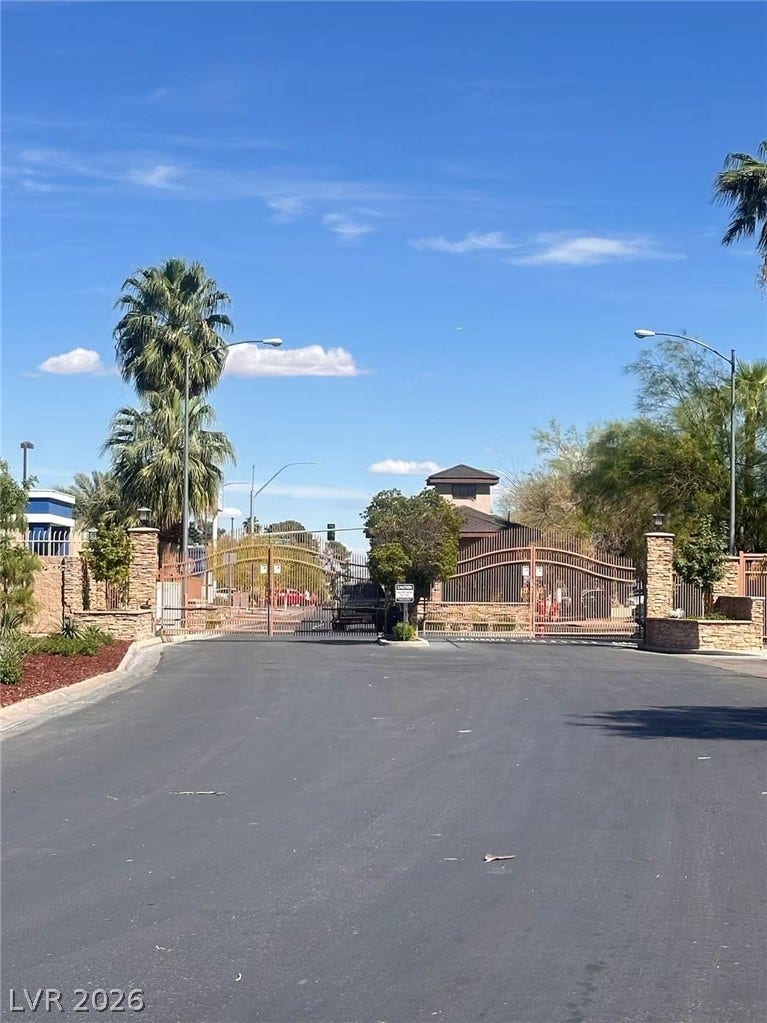 2838 Loveland Drive, #1608, Las Vegas, NV 89109 Secure gated entryway features prominent stone pillars and tall palm trees against a blue sky.