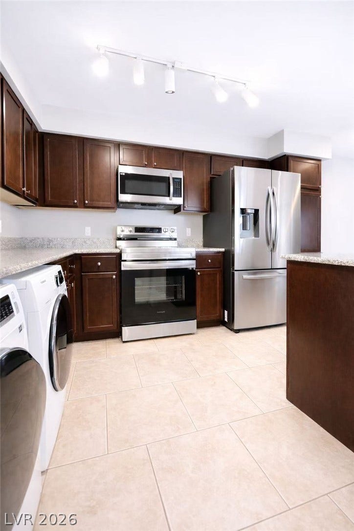 2838 Loveland Drive, #1608, Las Vegas, NV 89109 Rich wood cabinetry and light tile floors define this functional kitchen space.