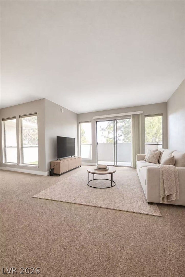 2838 Loveland Drive, #1608, Las Vegas, NV 89109 Wall-to-wall carpeting and sliding glass doors define this comfortable living space.