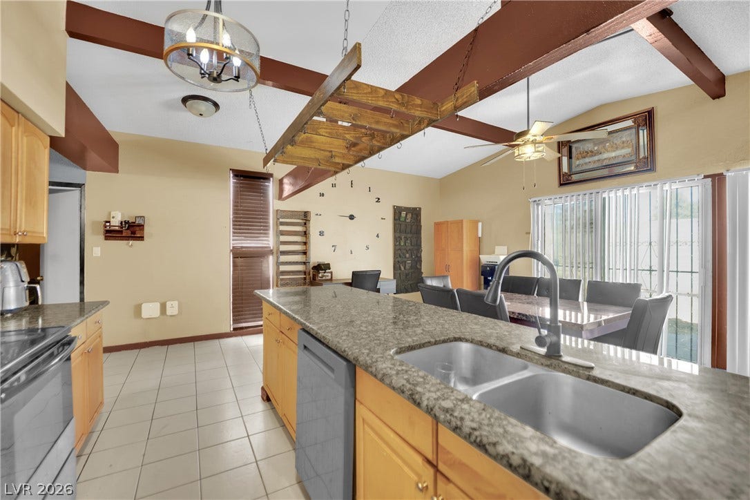 Exposed ceiling beams accent the tiled kitchen and adjoining dining area with sliding glass doors.
