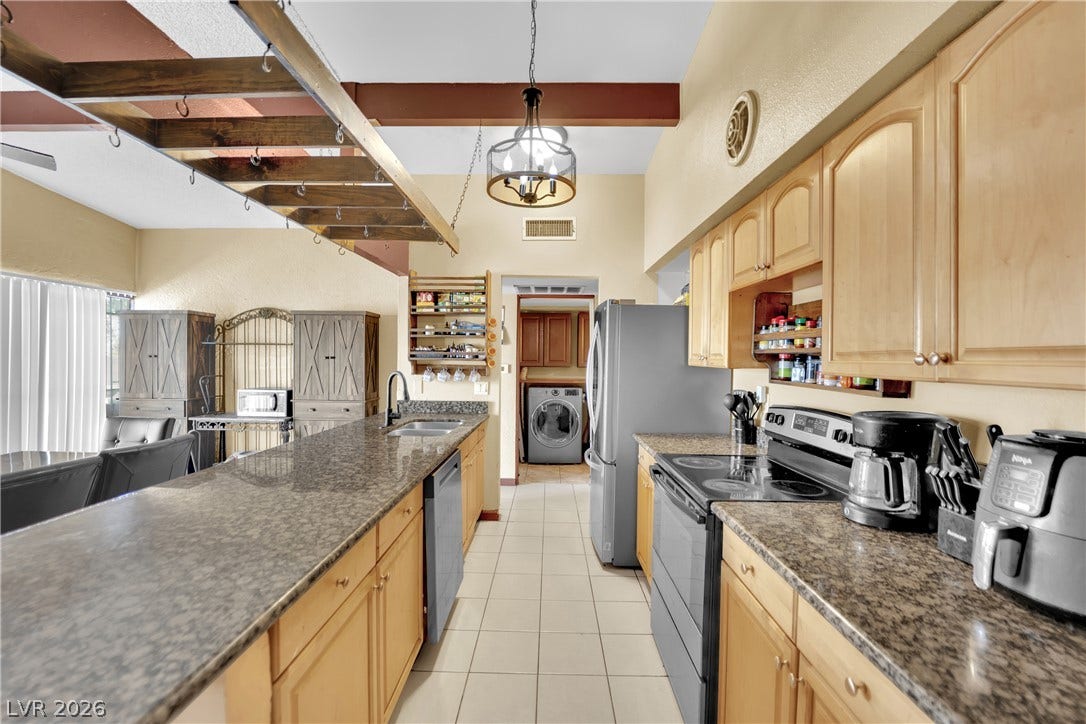 Gleaming stone countertops and classic wood cabinetry define this functional kitchen workspace.