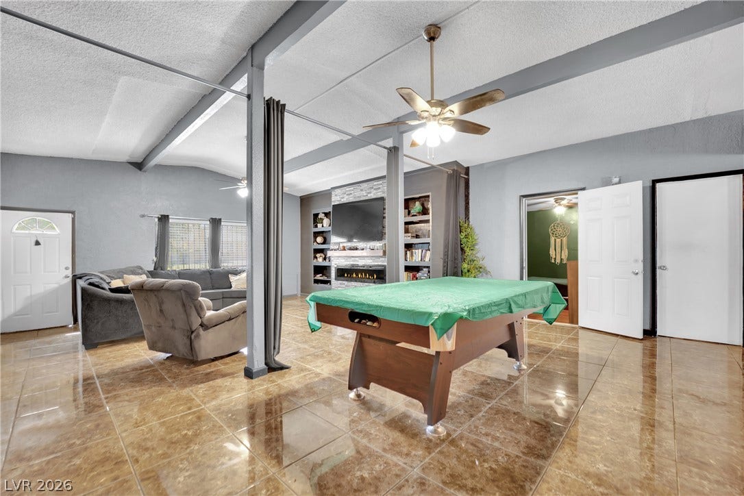 Polished tile floors and exposed ceiling beams define this open recreation space.