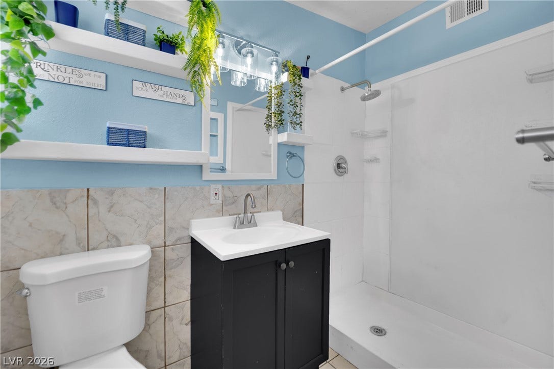 Tiled walls and a walk-in shower define this functional washroom space.