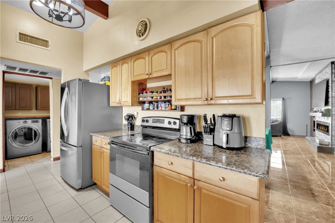 Ample wooden cabinetry and stone countertops anchor this central kitchen preparation area.