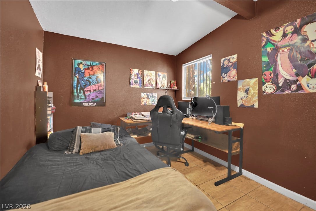 Tiled flooring and a exposed wooden ceiling beam accent this cozy bedroom space.