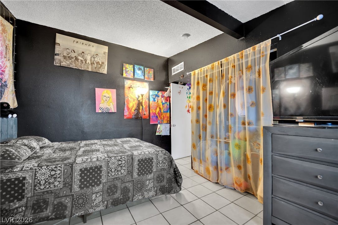 Exposed ceiling beams and tiled flooring define this distinctive bedroom space.