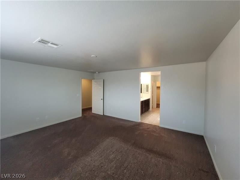 Plush carpeting and an open doorway leading to the bathroom define this quiet suite.
