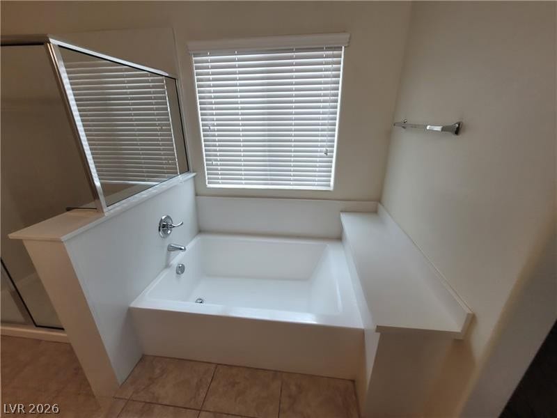 An inviting soaking tub pairs beautifully with neutral tile flooring.