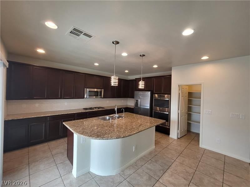 Rich dark cabinetry pairs beautifully with stone countertops and a curved center island.