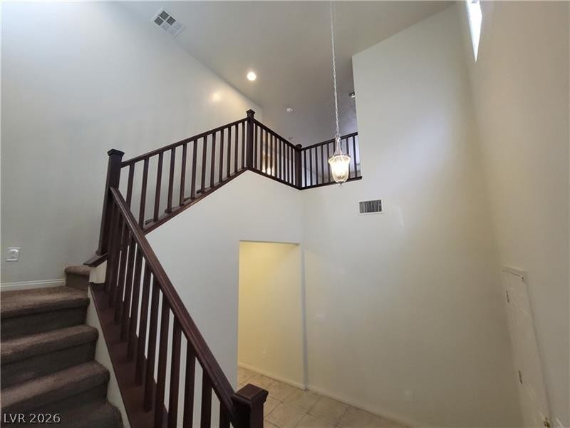 High ceilings and a dramatic wooden staircase create a grand first impression.