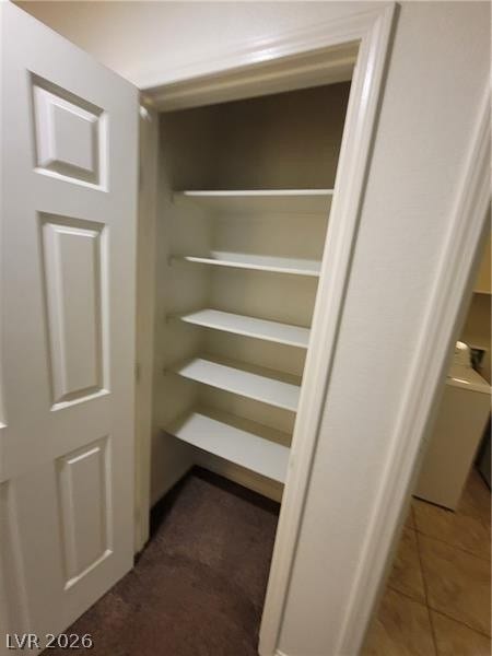 Ample built-in shelving provides generous storage space inside this tidy closet.