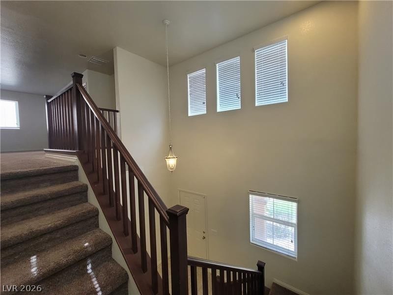 Soaring ceilings and an open staircase define this light-filled entry foyer.
