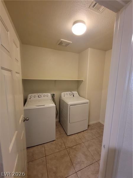 Tiled flooring and overhead shelving maximize utility in this dedicated laundry space.
