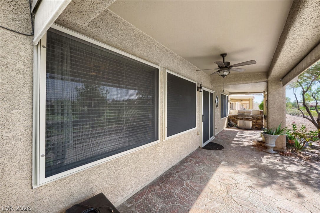 7421 Shelduck Street, North Las Vegas, NV 89084 A spacious covered patio features flagstone flooring alongside textured stucco walls and integrated outdoor kitchen.