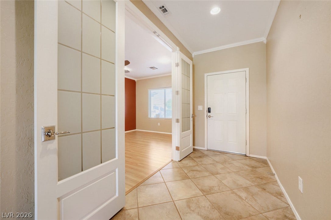 7421 Shelduck Street, North Las Vegas, NV 89084 Glazed interior doors open to versatile living spaces from this tiled entry foyer.