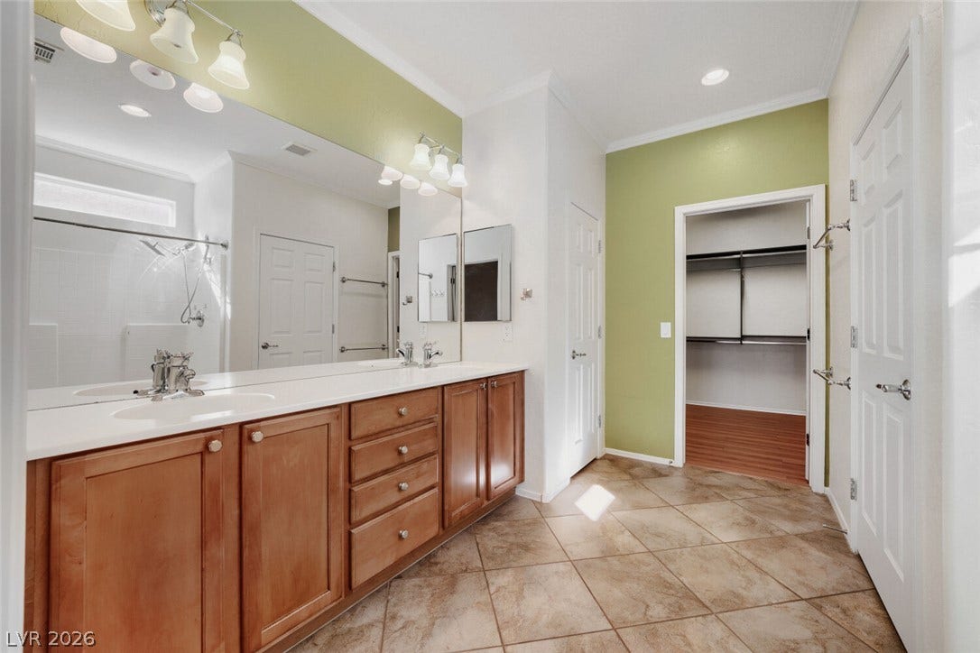 7421 Shelduck Street, North Las Vegas, NV 89084 Warm wood cabinetry and durable tile flooring define this spacious bathroom layout.