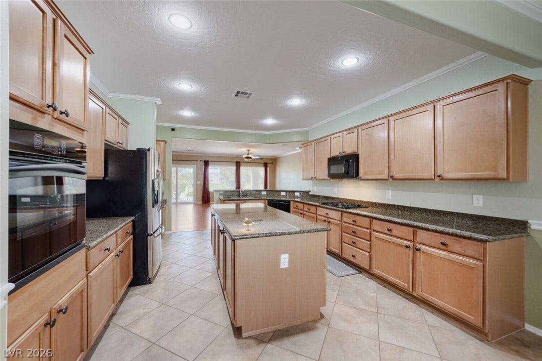 7421 Shelduck Street, North Las Vegas, NV 89084 Ample wooden cabinetry and stone countertops anchor this functional layout.