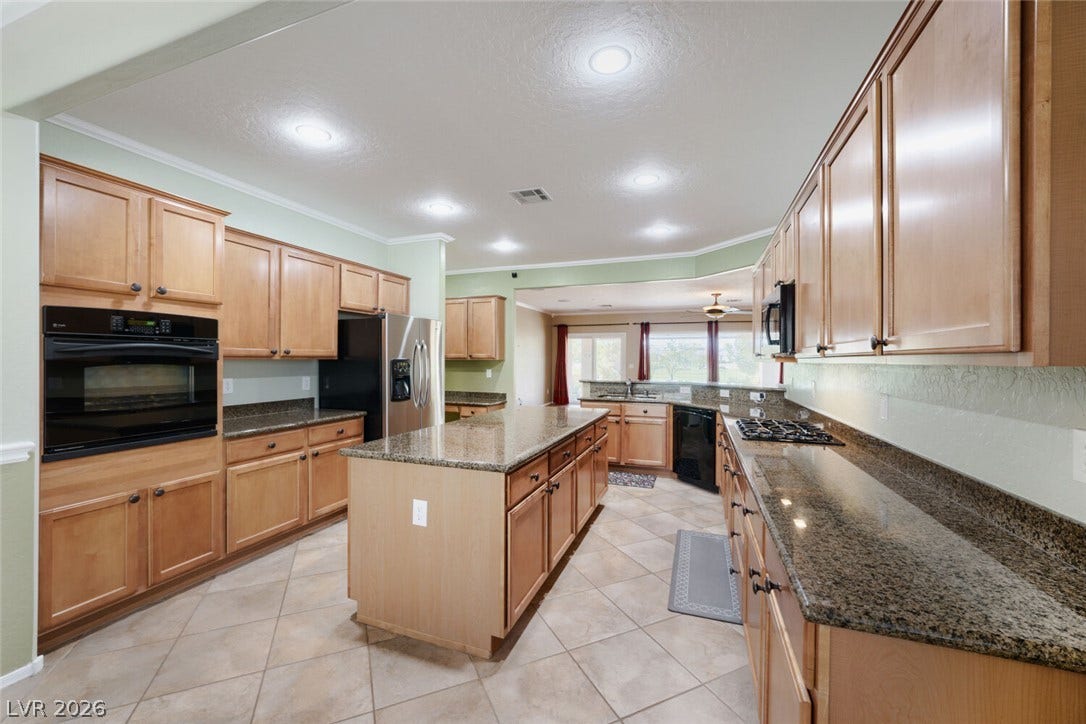 7421 Shelduck Street, North Las Vegas, NV 89084 Ample wooden cabinetry and stone countertops anchor this spacious kitchen with a central island.