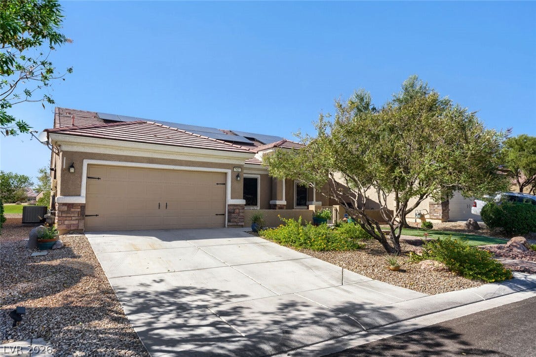 7421 Shelduck Street, North Las Vegas, NV 89084 Solar panels crown this modern single-story residence featuring stucco finishes and low-maintenance desert landscaping.