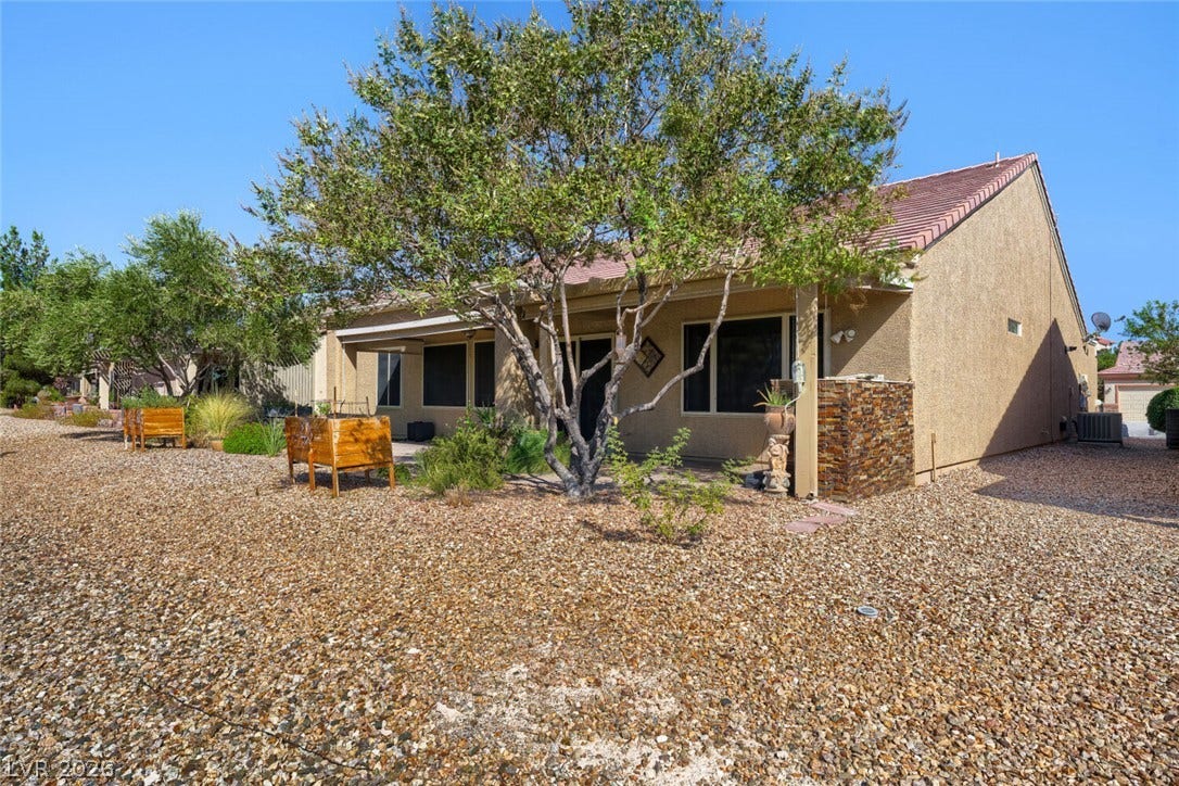 7421 Shelduck Street, North Las Vegas, NV 89084 A spacious gravel yard surrounds this single-story home featuring a covered patio and stone-clad pillars.