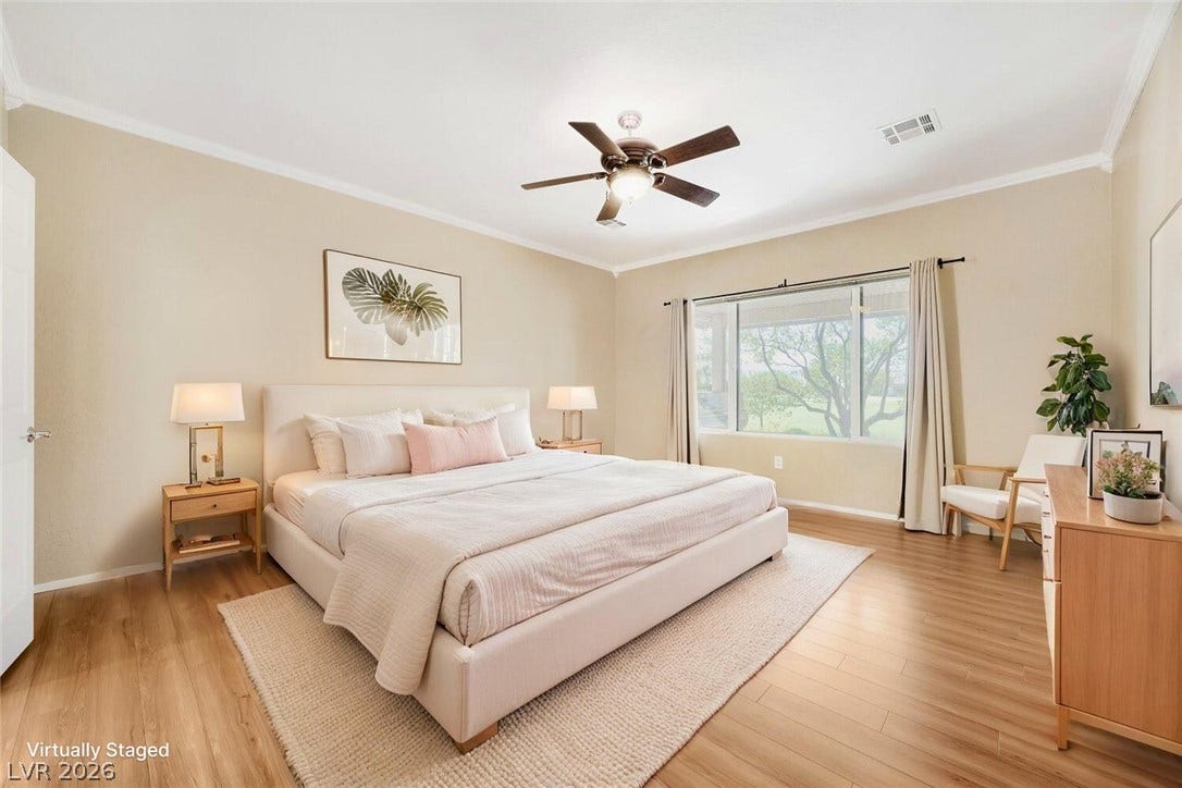7421 Shelduck Street, North Las Vegas, NV 89084 Warm wood flooring and classic crown molding frame this welcoming bedroom space.