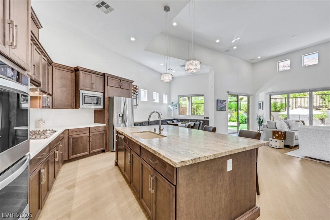 An expansive gourmet kitchen showcases sleek stainless-steel appliances flows effortlessly into the light filled living area living area.
